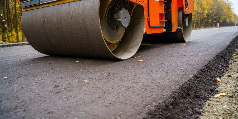 Industrial pavement truck. Laying fresh asphalt on construction site. Heavy machine industry. Mechanical engineering..